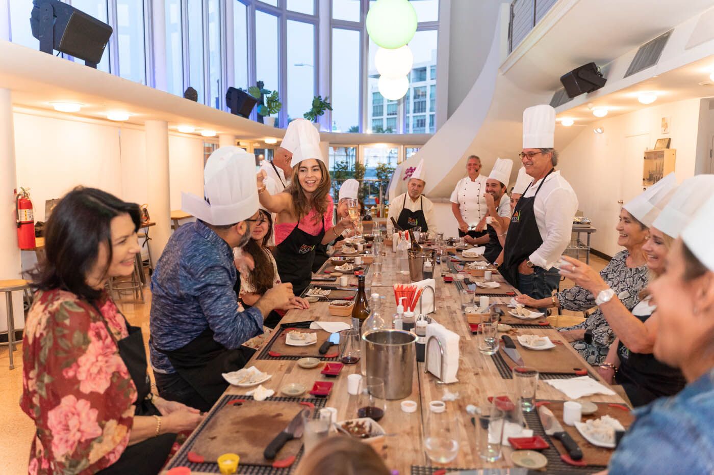 A group of adults cooking in skillets, try one of our cooking classes.